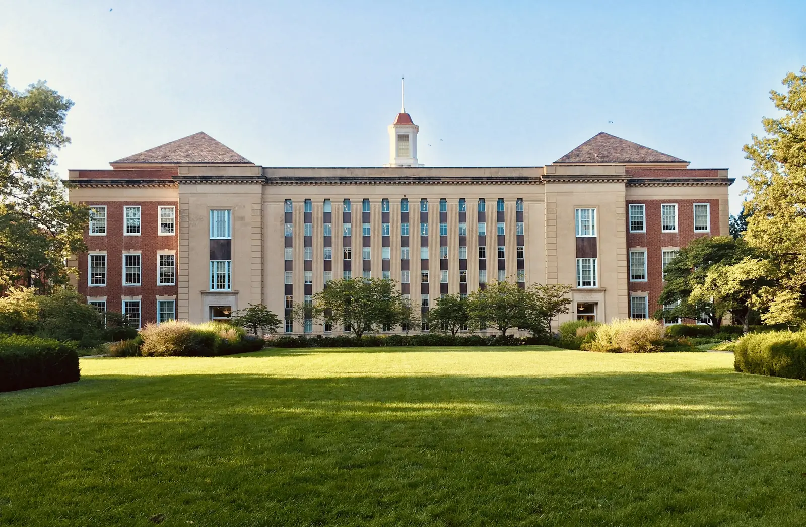 A brick civic building behind a lawn