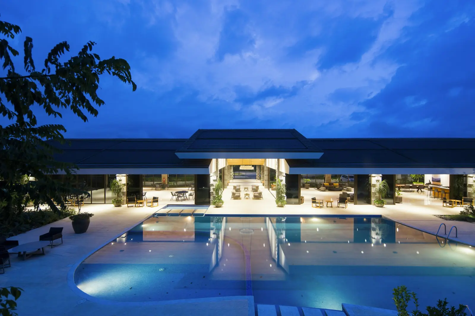 A resort pool and pavilion lit at night
