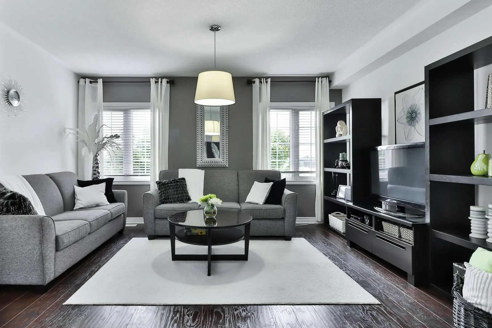 A living room with a wall-mounted TV and media shelving