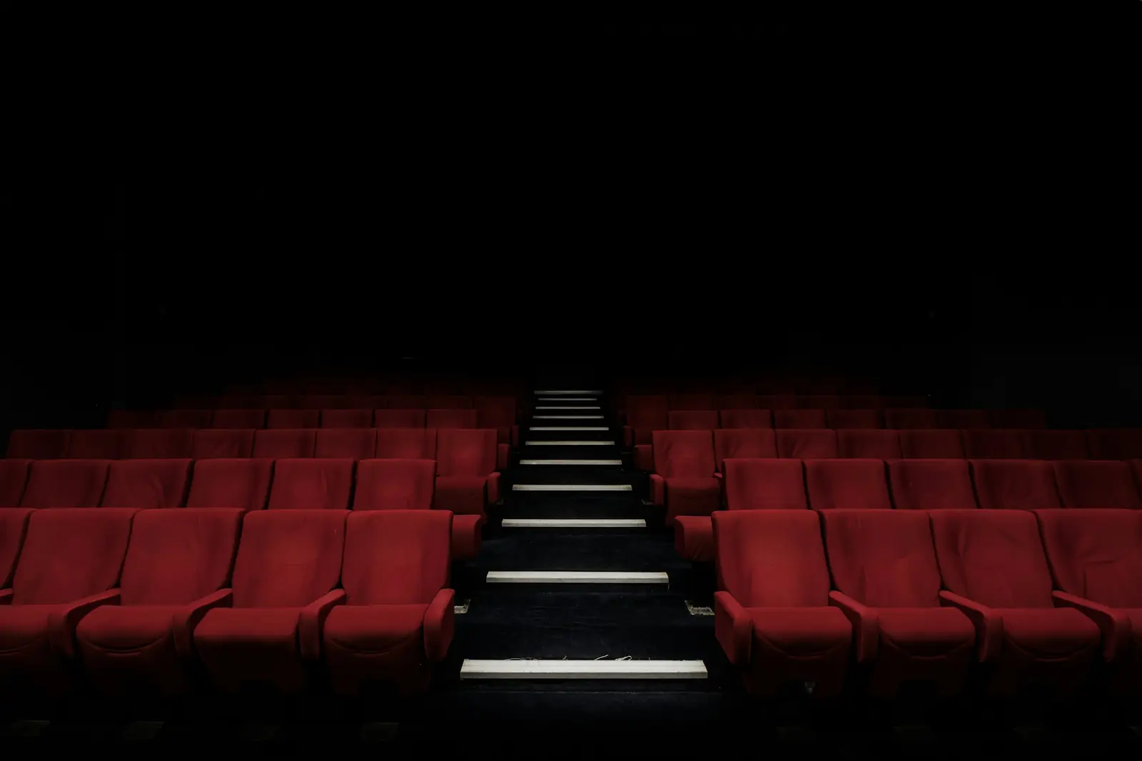 Rows of cinema seats in a dark auditorium