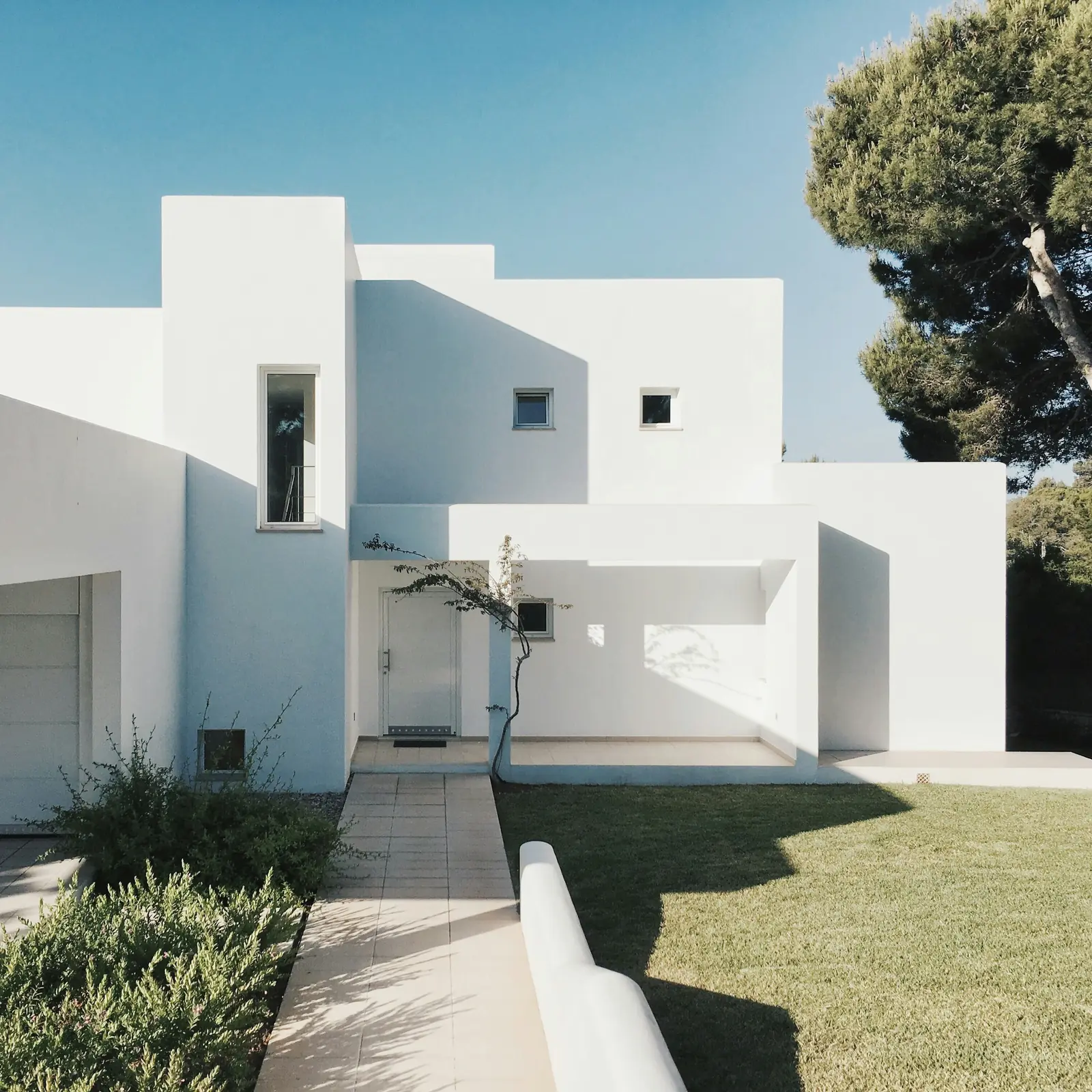 A white, minimal house under a clear sky